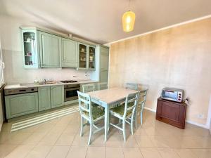 a kitchen with green cabinets and a table and chairs at Villetta My Sea in Spotorno