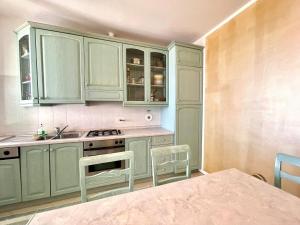 a kitchen with green cabinets and a sink at Villetta My Sea in Spotorno