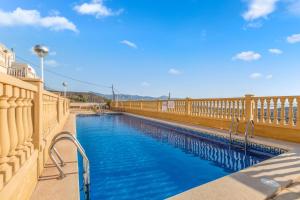 a swimming pool with blue water on a balcony at Apartment in Bolnuevo in Bolnuevo