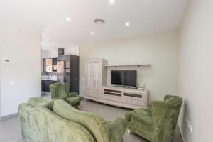 a living room with two chairs and a television at Apartamento Torero ii in Marchena