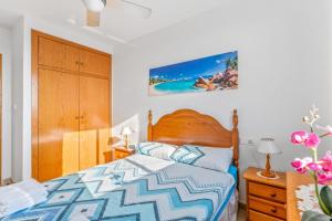 a bedroom with a bed with a blue and white comforter at Apartment in Bolnuevo in Bolnuevo +28 photos