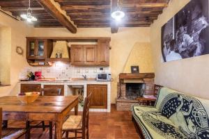 a kitchen with a wooden table and a dining room at Agriturismo Podere Marroneto in Monticiano