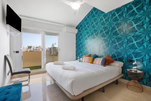 a bedroom with a large bed with a blue wall at Luxury in Puerto Marina in Benalmádena +32 photos