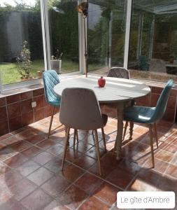 a table with chairs and an apple on top of it at Le Gîte d’Ambre in Poullaouen