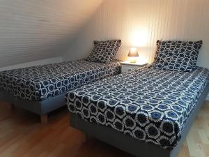 two beds sitting next to each other in a room at Le Gîte d’Ambre in Poullaouen