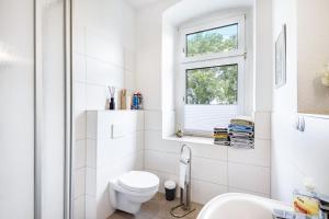 a white bathroom with a toilet and a window at Haus Wipperblick in Osmarsleben