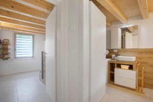 a bathroom with white walls and wooden ceilings at Maison Millet Ozein in Aymavilles +23 photos