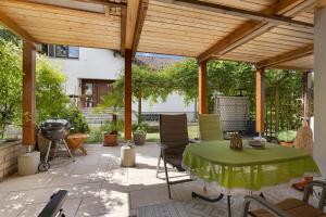 a patio with a table and chairs under a wooden pergola at Ferienwohnung Janko in Meßstetten