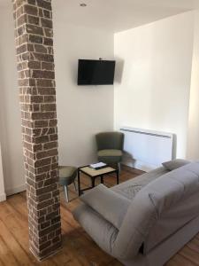 a living room with a bed and a brick wall at Famille in La Bourboule