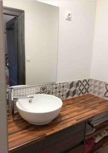 a bathroom with a white sink and a mirror at Famille in La Bourboule