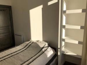 a bedroom with a bed and an empty shelf at Famille in La Bourboule