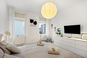 a white living room with a tv and a couch at Ferienwohnung Agnes in Dessau