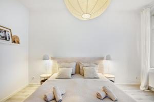a white bedroom with a large bed with two pillows at Ferienwohnung Agnes in Dessau