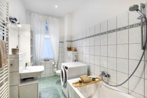 a white bathroom with a sink and a toilet at Ferienwohnung Agnes in Dessau +13 photos