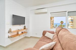 a living room with a couch and a flat screen tv at Playa Algarrobo Costa in Algarrobo-Costa