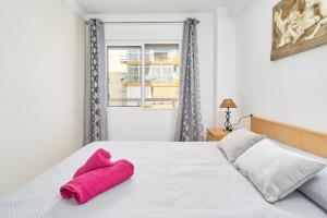 a bedroom with a bed with a pink towel on it at Playa Algarrobo Costa in Algarrobo-Costa +23 photos
