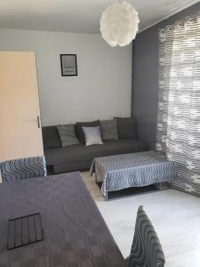 a living room with a couch and a bed at La Maison Defanny - 1 in Muides-sur-Loire