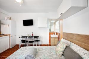 a bedroom with a bed and a table and a kitchen at Estudio La Morena in El Pris