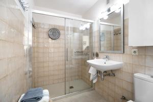 a bathroom with a glass shower and a sink at Doña Amparo chipiona Playa de Regla in Chipiona +13 photos