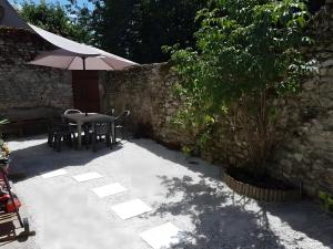 a patio with a table and an umbrella at La Maison Defanny - 1 in Muides-sur-Loire