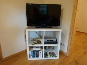 a tv on a white stand with a tv at Ferienhaus am Leiselbach in Leisel