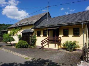 a yellow house with a black roof at Ferienhaus am Leiselbach in Leisel