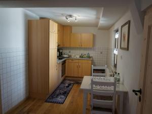 a small kitchen with wooden cabinets and a table at Ferienhaus am Leiselbach in Leisel