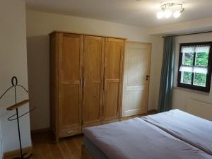 a bedroom with a bed and a large wooden cabinet at Ferienhaus am Leiselbach in Leisel