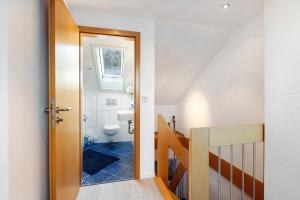 a bathroom with a toilet and a staircase with a door at Haus Frank in Wehr +12 photos