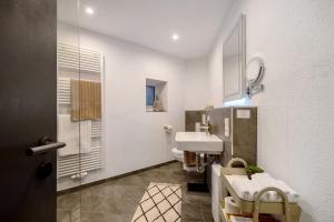 a white bathroom with a sink and a mirror at My Little Suite in Illingen +28 photos
