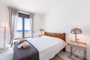 a bedroom with a bed and a window with the ocean at Duplex jlc in Mojácar +24 photos