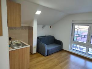 a kitchen with a blue chair in a room at Apartmani Gradac in Valjevo