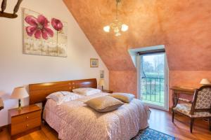 a bedroom with a large bed and a window at Clos Des Hogues - Chambres d'hôtes in Saint-Léonard