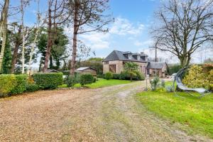 a home with a gravel driveway and a house at Clos Des Hogues - Chambres d'hôtes in Saint-Léonard