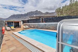 a villa with a swimming pool and mountains in the background at Villalmar in Famara