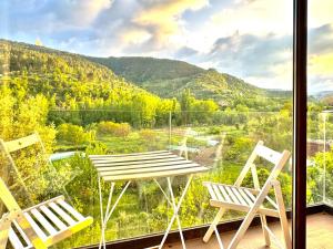a table and two chairs on a balcony with a view at Duende in Olba