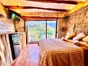 a bedroom with a large bed and a large window at Duende in Olba