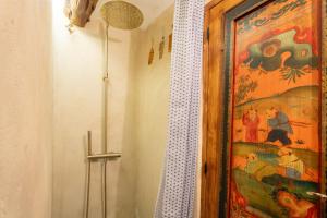 a bathroom with a shower curtain and a painting on the wall at Duende in Olba
