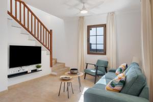 a living room with a blue couch and a tv at Casa Fama con piscina privada clima in Yaiza
