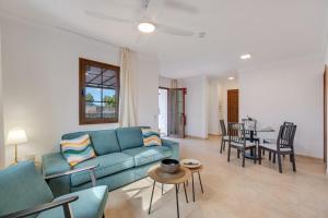 a living room with a blue couch and a table at Casa Fama con piscina privada clima in Yaiza