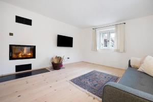 a living room with a couch and a fireplace at Armenhaus 1828 in Görisried