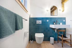 a bathroom with a toilet and a sink at Armenhaus 1828 in Görisried +9 photos