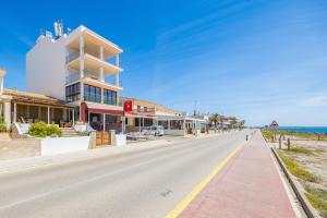 an empty street with a building and the ocean at Brisas Vista Mar in Sa Ràpita