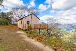 a wooden barn on a hill with a dirt road at Cabañas Entre Castaños in Jubrique