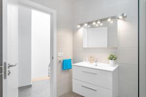 a white bathroom with a sink and a mirror at Sparrow in La Santa +12 photos