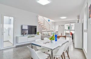 a kitchen and dining room with a white table and chairs at Sparrow in La Santa