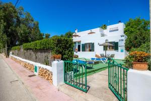 a white house with a fence and a yard at Apartamento Felipe 2-1 in Cacla D'or