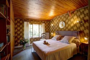 a bedroom with a large bed with a wooden ceiling at Gîte Des Roties in Poncins