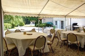 a group of tables and chairs under a tent at Gîte Des Roties in Poncins