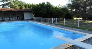 a pool with blue water in front of a house at Gîte Des Roties in Poncins